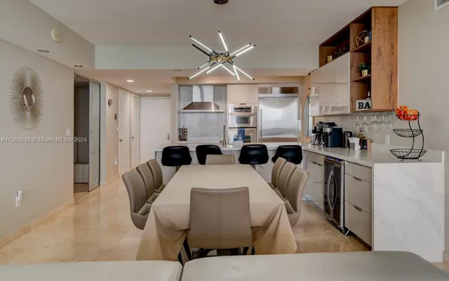 a very nice looking open dining room with kitchen island furniture and a chandelier