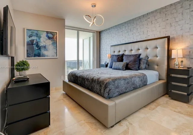 a bedroom with a large bed and a chandelier