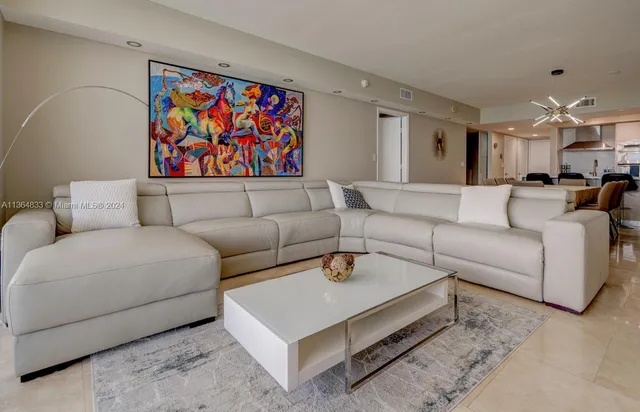 a living room with furniture a couch and a painting on the wall