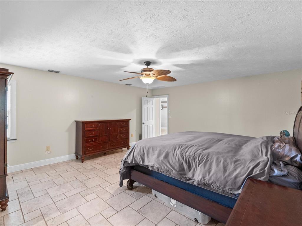 5904 Springrun Court Holiday, FL 34690 - Photo 24 of 53 a bedroom with a bed and a chandelier