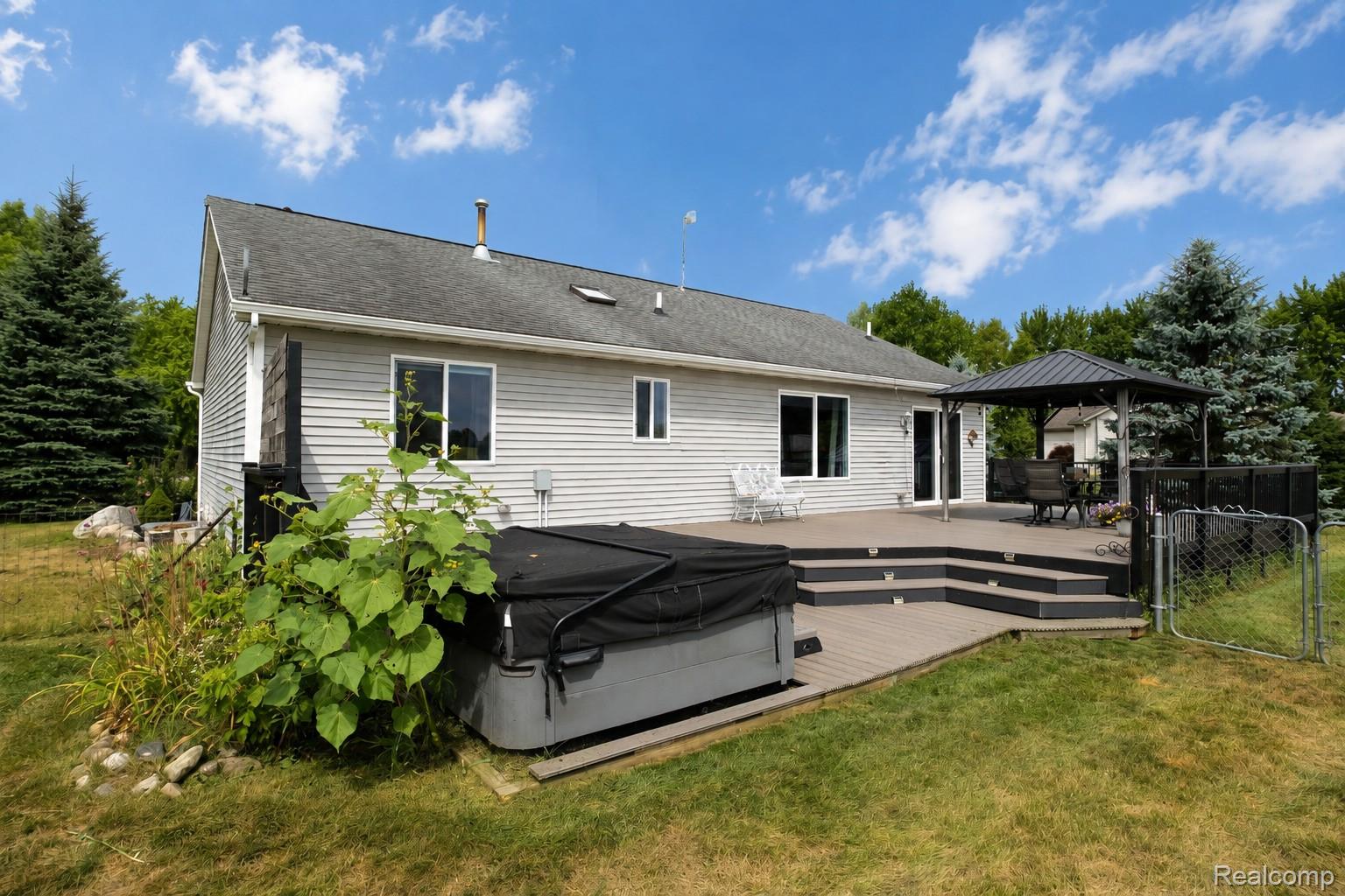 13063 Seymour Road Gaines, MI 48436 - Photo 25 of 29 Multi-level composite deck with integrated steps, hot tub, and detached gazebo