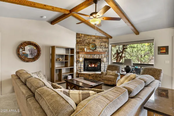 a living room with furniture a large window and a fireplace