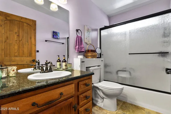 a bathroom with a granite countertop toilet sink and mirror