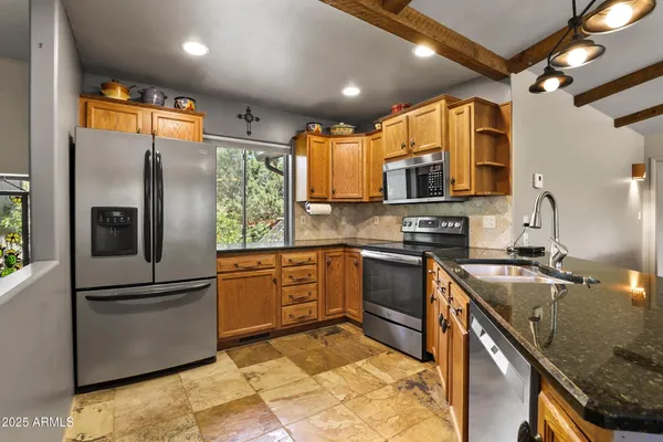 a kitchen with granite countertop a sink stainless steel appliances and cabinets