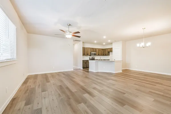 a view of an empty room and window with wooden floor