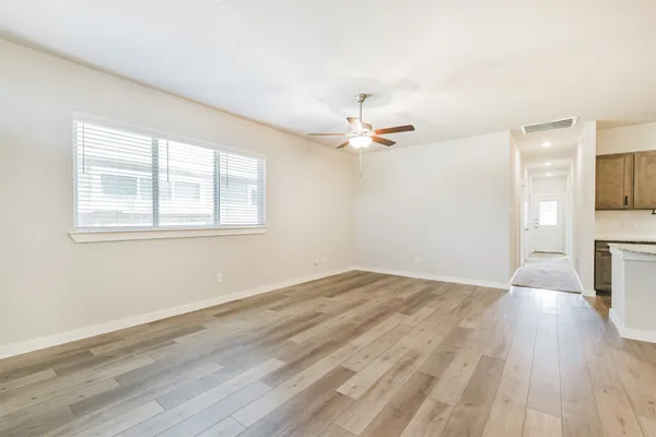 a view of an empty room and window with wooden floor