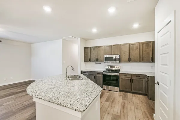 a kitchen with stainless steel appliances granite countertop a sink stove and cabinets