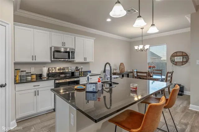 a kitchen with kitchen island granite countertop a sink center island and cabinets
