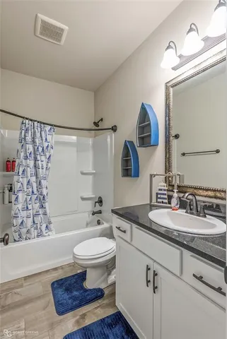 a bathroom with a sink a toilet a mirror and shower