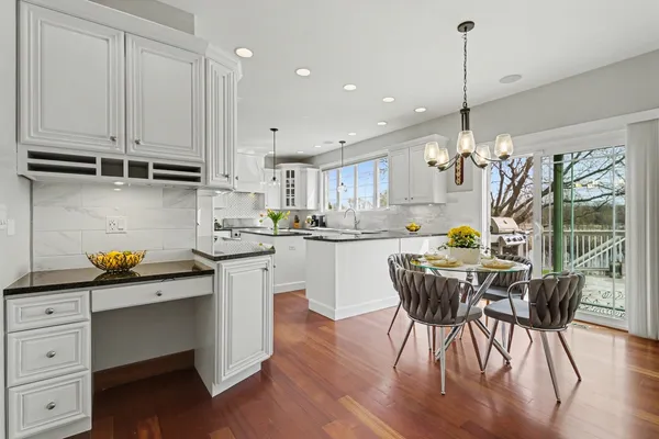 a kitchen with stainless steel appliances granite countertop a sink a stove and a wooden floors