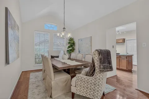 a dining room with furniture a chandelier and wooden floor