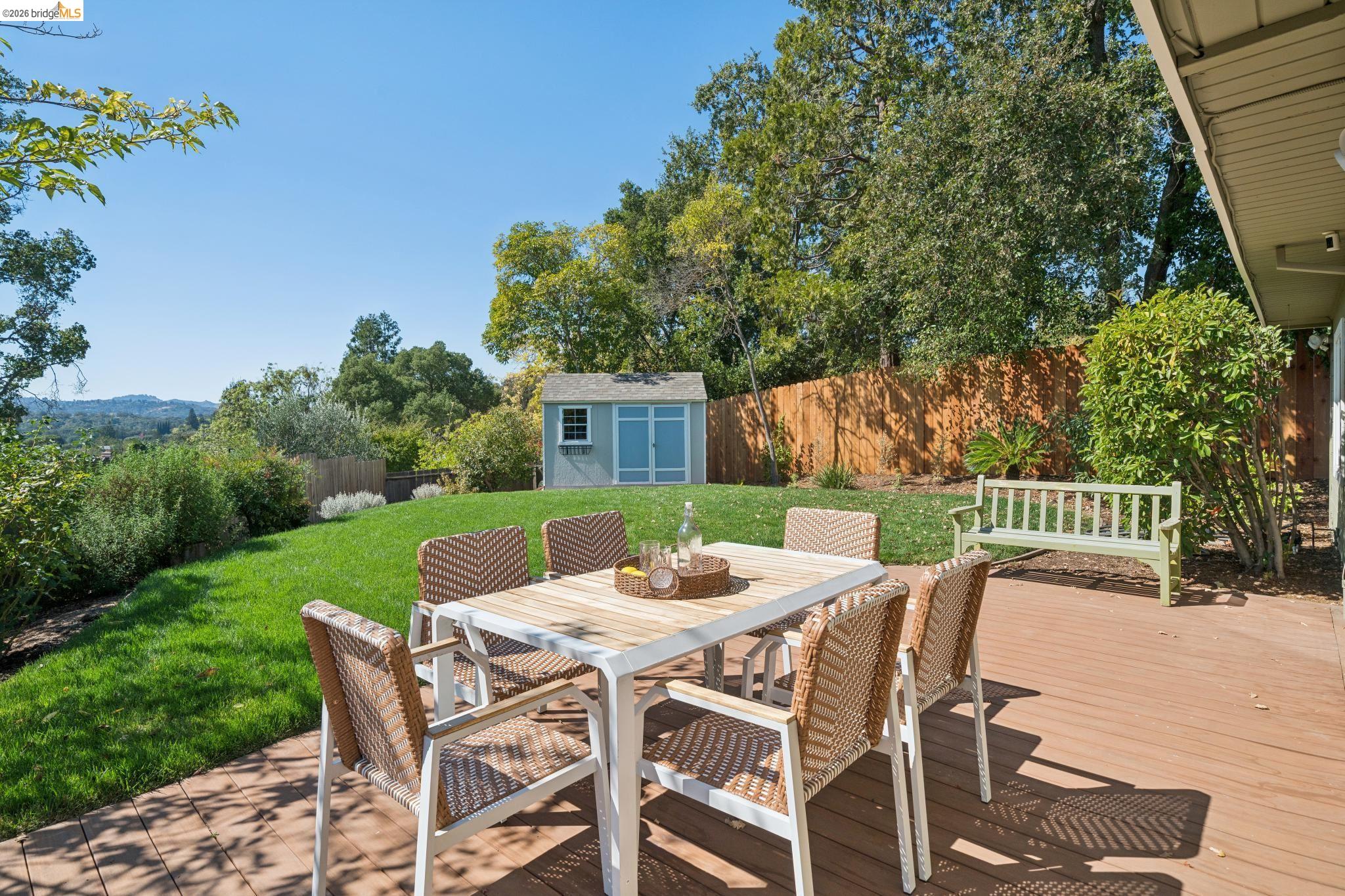 1321 Sunset Loop Lafayette, CA 94549 - Photo 32 of 49 Expansive wood-finish deck with a manicured lawn, perimeter fencing, and a detached storage shed