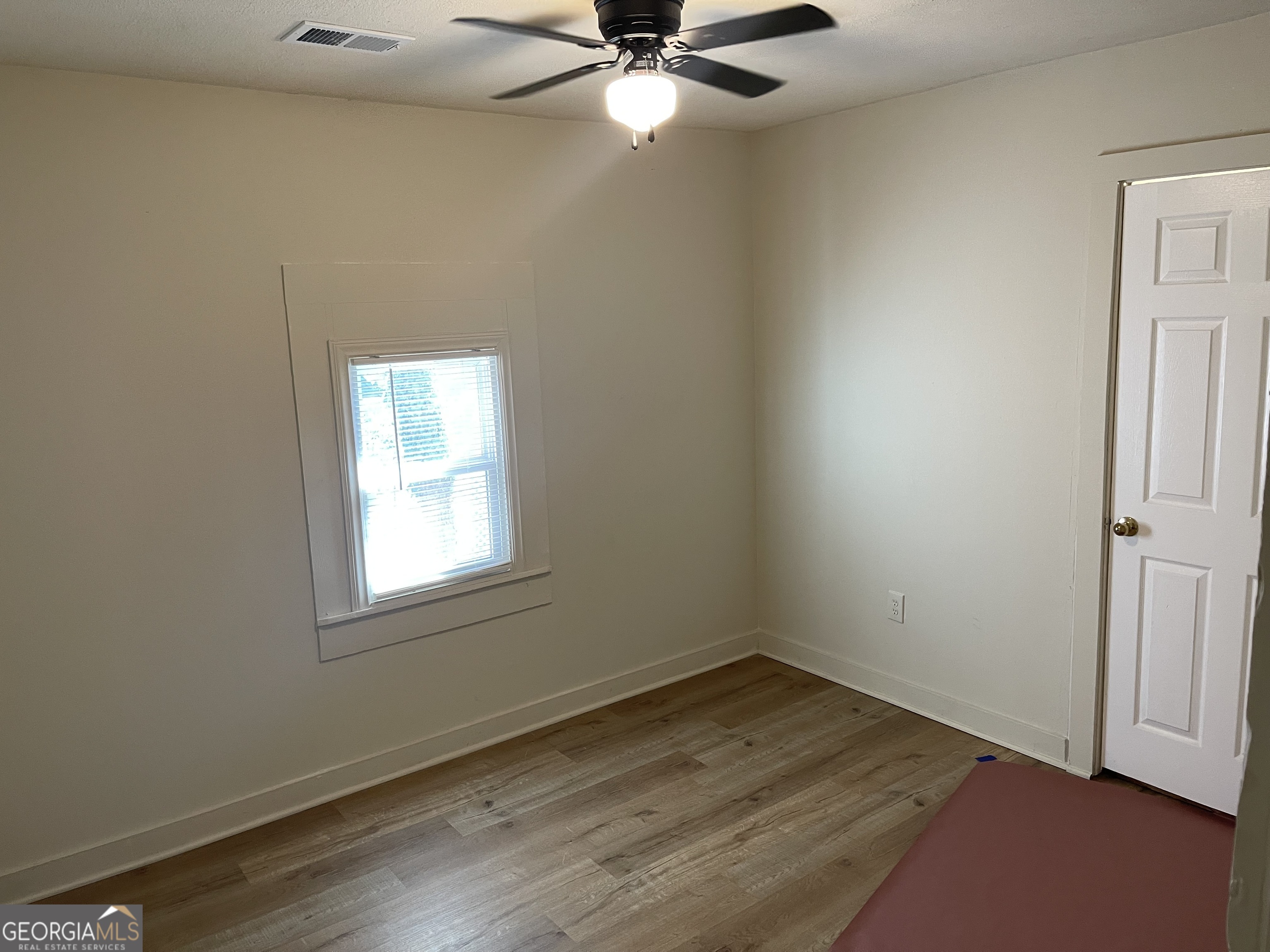 478 South Pond Street Toccoa, GA 30577 - Photo 19 of 46 an empty room with a window and wooden floor