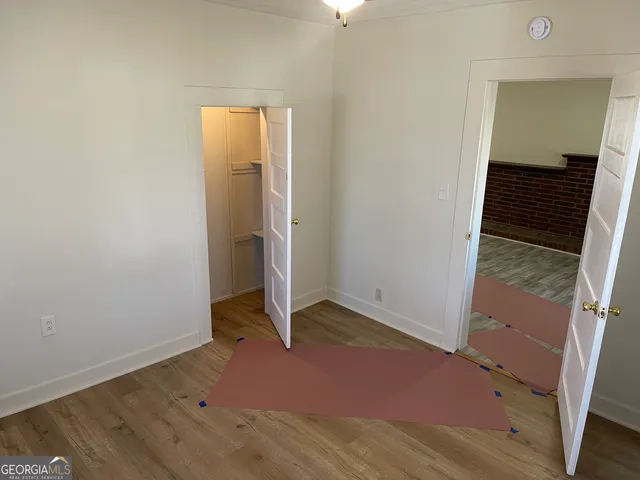 an empty room with wooden floor and closet