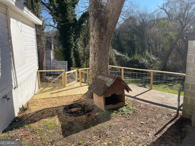 a view of a deck with a floor to ceiling window and wooden fence