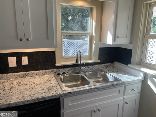 a kitchen with granite countertop sink and cabinets