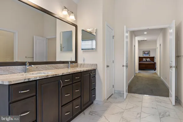 a spacious bathroom with a granite countertop sink and a mirror