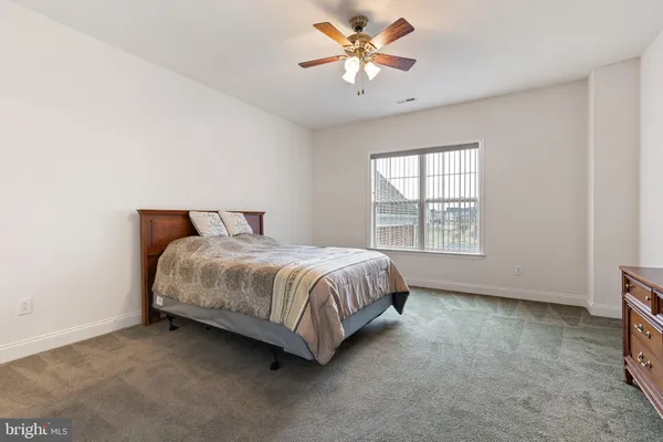 a spacious bedroom with a bed and a window