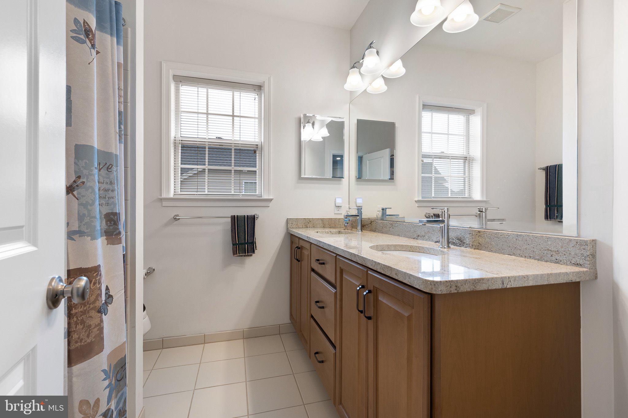 1020 Matthew Way New Castle, DE 19720 - Photo 35 of 55 a bathroom with a granite countertop sink a mirror and a shower