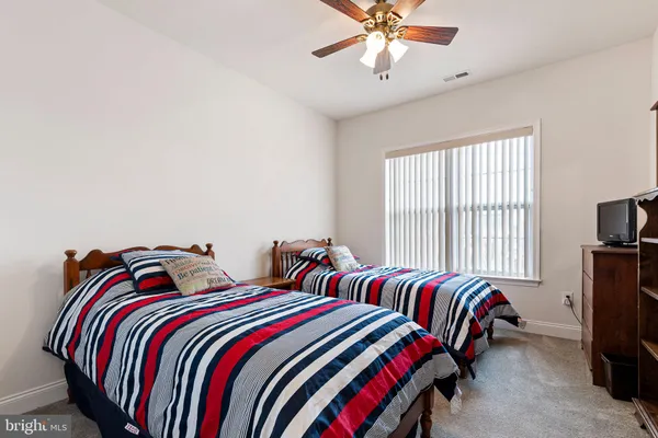 a bedroom with two beds and a chandelier