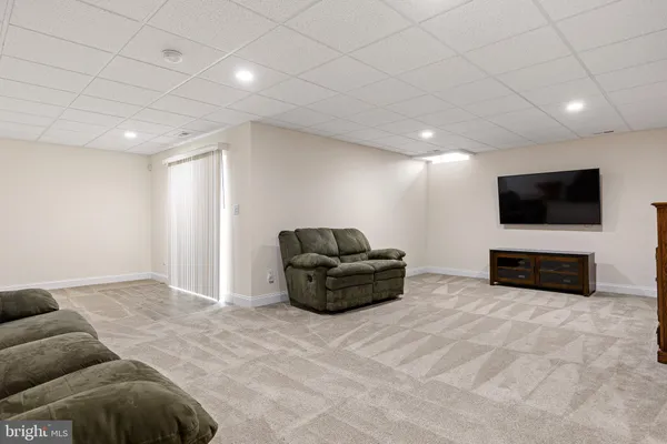 a living room with furniture a window and a flat screen tv