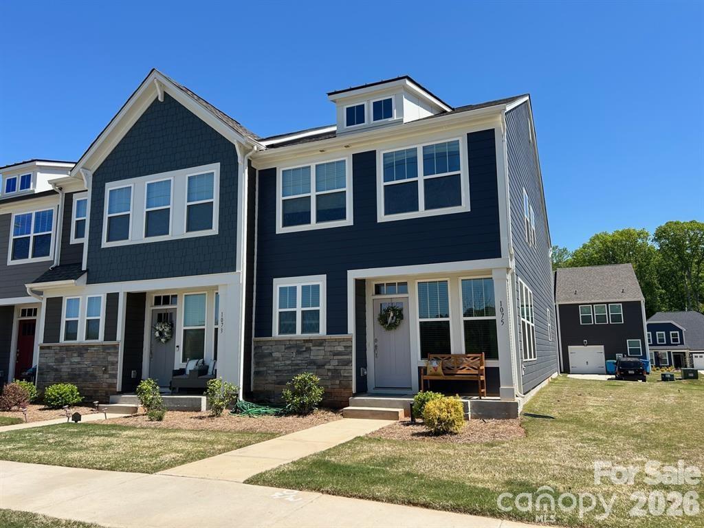 a front view of a house with garden and seating area