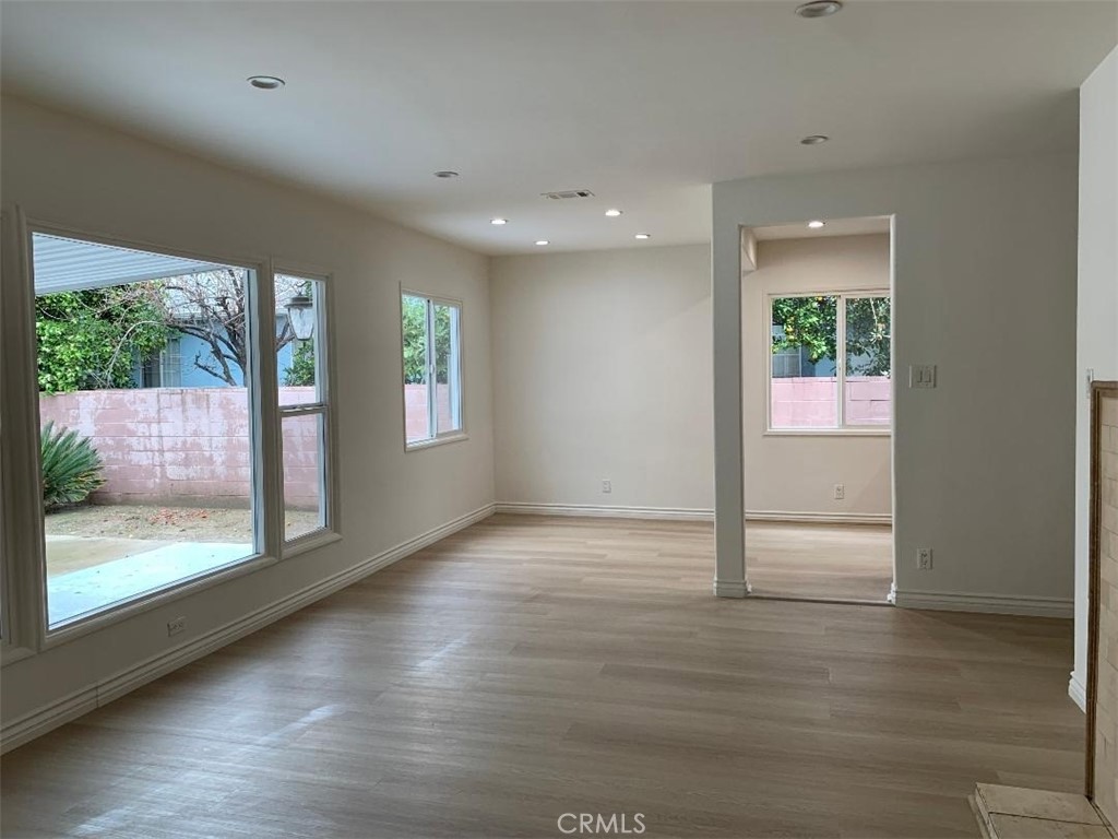 18233 Welby Way Reseda, CA 91335 - Photo 13 of 15 a view of an empty room with wooden floor and a window