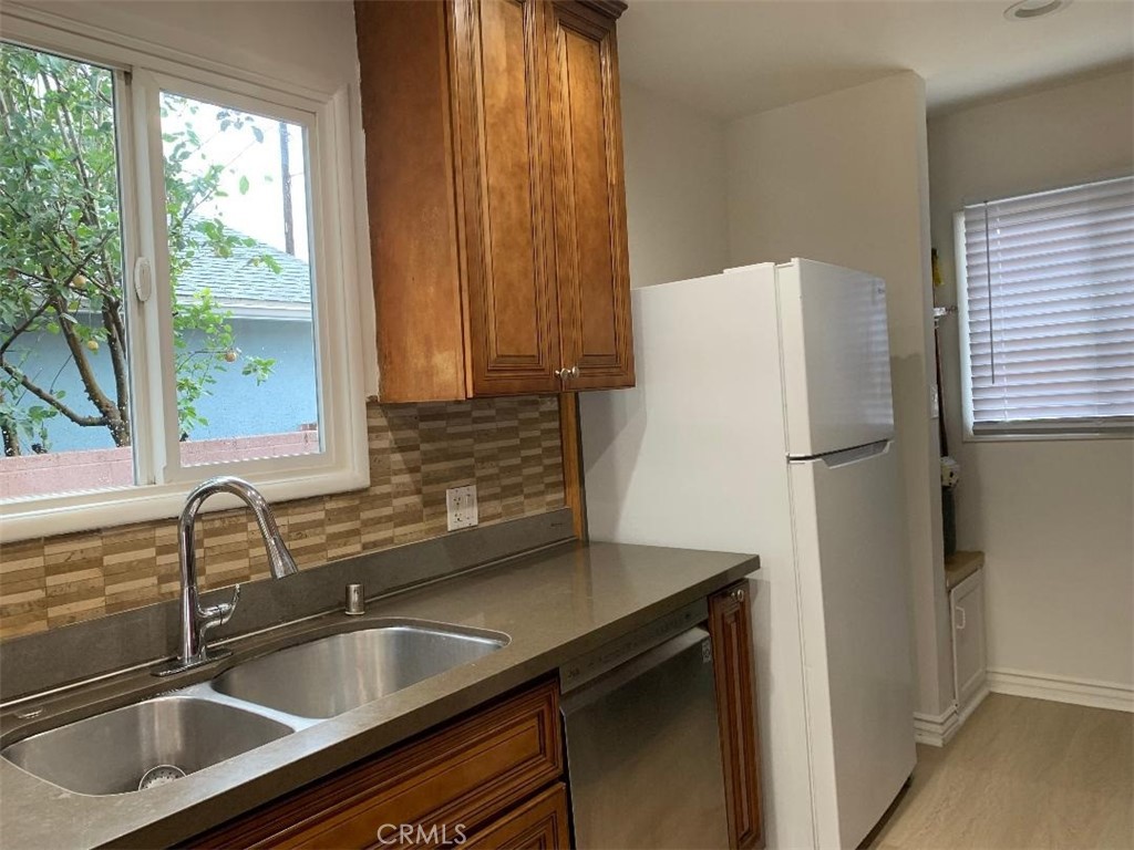 18233 Welby Way Reseda, CA 91335 - Photo 5 of 15 a kitchen with a refrigerator and a sink