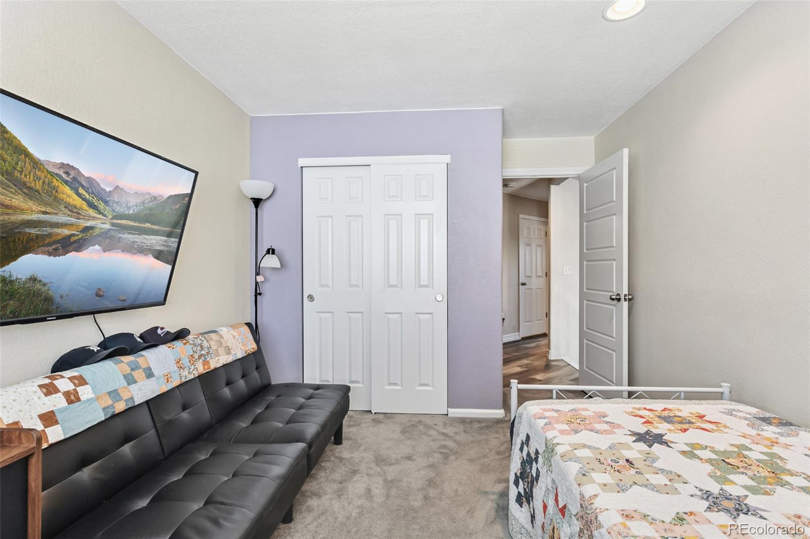 334 Octillo Street Brighton, CO 80601 - Photo 18 of 39 a bedroom with a bed and wooden floor