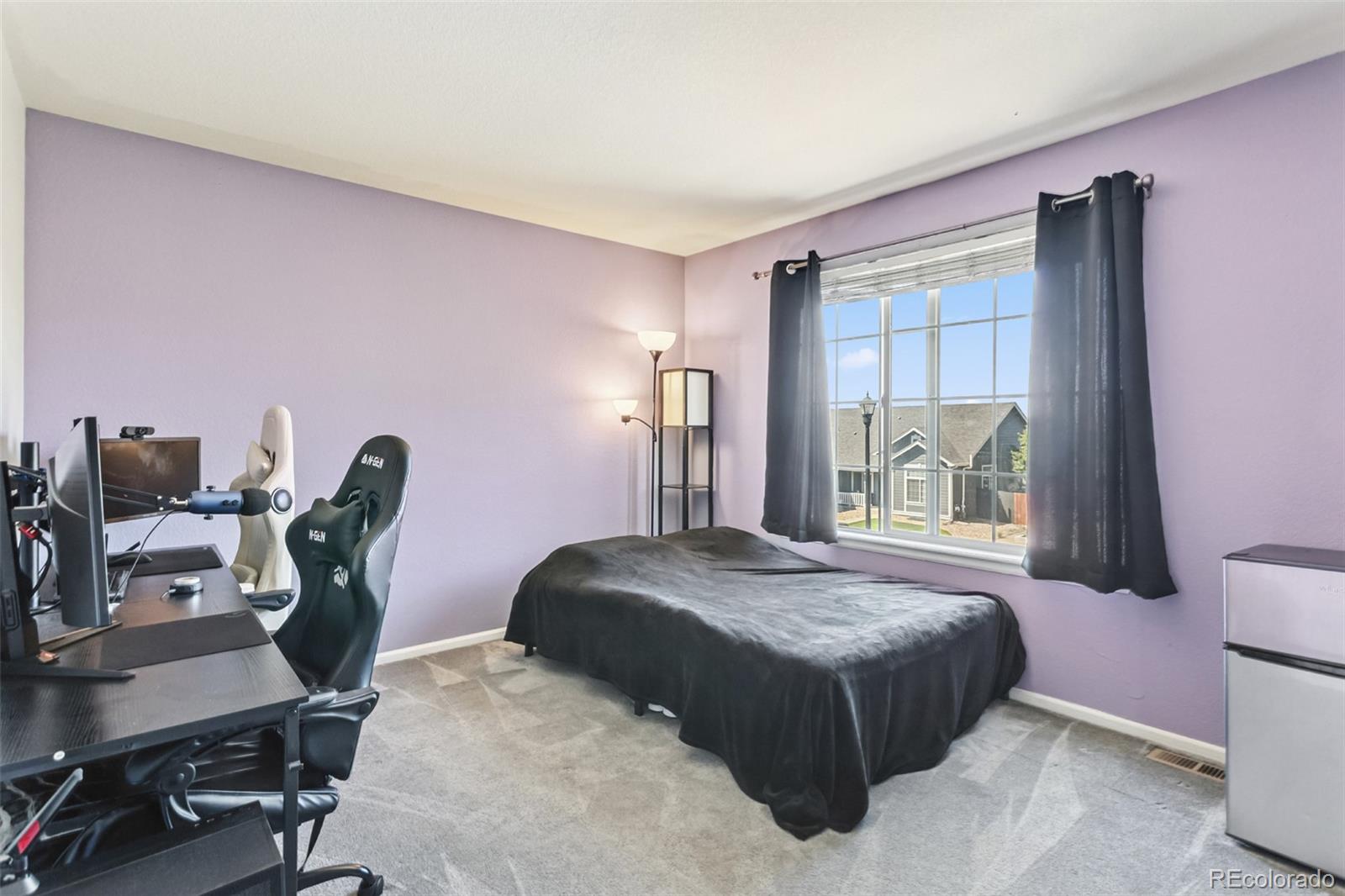 334 Octillo Street Brighton, CO 80601 - Photo 24 of 39 a bedroom with a bed and large windows