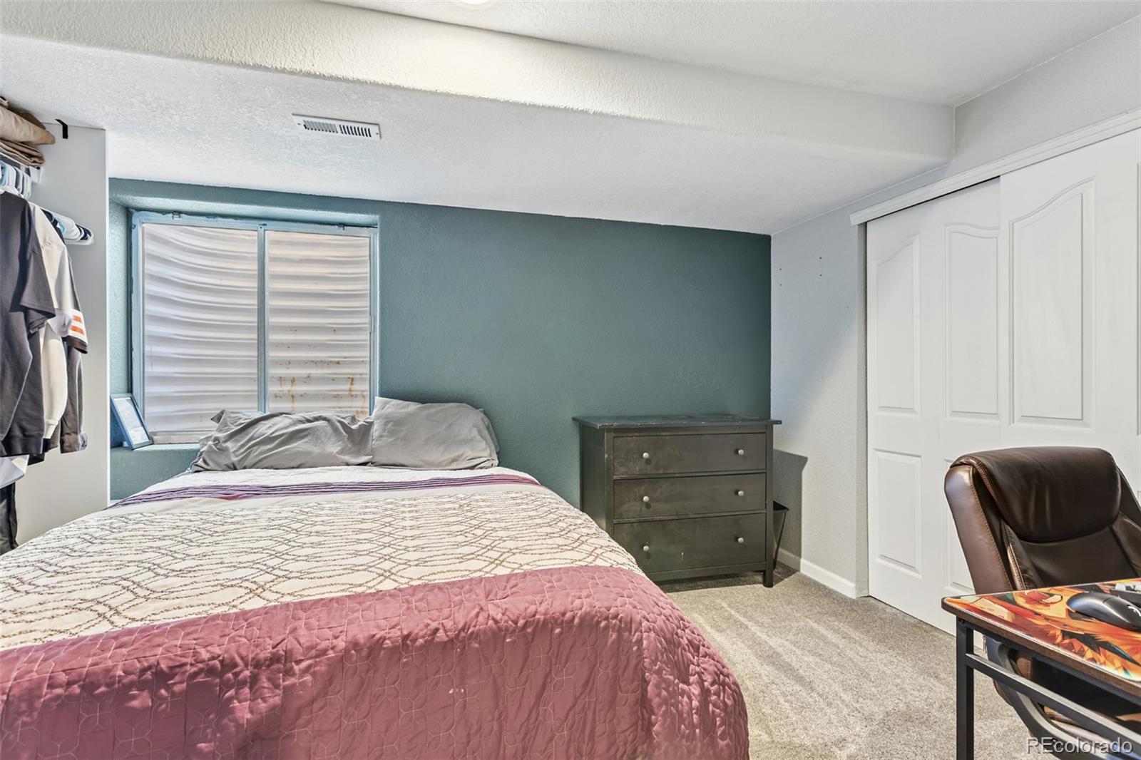 334 Octillo Street Brighton, CO 80601 - Photo 26 of 39 a bedroom with a bed and a chair