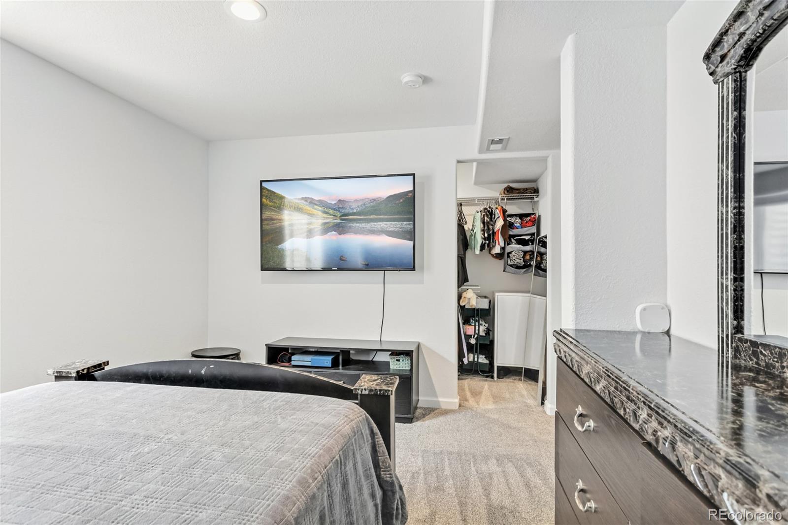 334 Octillo Street Brighton, CO 80601 - Photo 37 of 39 a bedroom with a bed and a flat screen tv