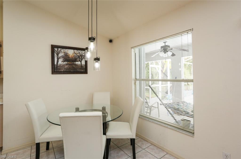 7775 Scarlet Court Naples, FL 34104 - Photo 11 of 30 Dining space with ceiling fan, light tile patterned flooring, and vaulted ceiling