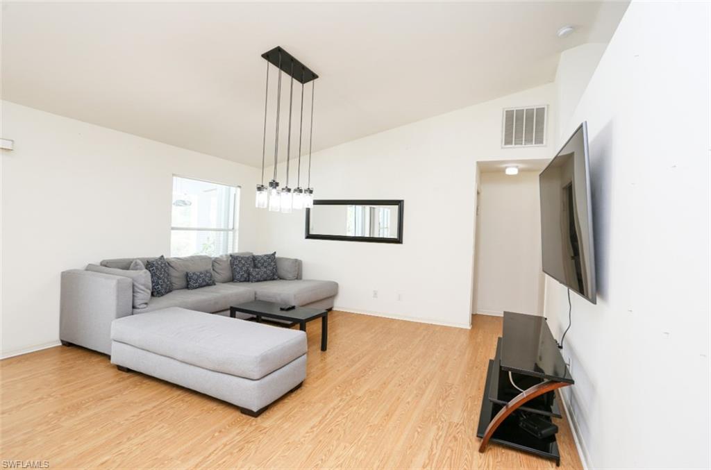 7775 Scarlet Court Naples, FL 34104 - Photo 12 of 30 Living room featuring hardwood / wood-style floors and lofted ceiling