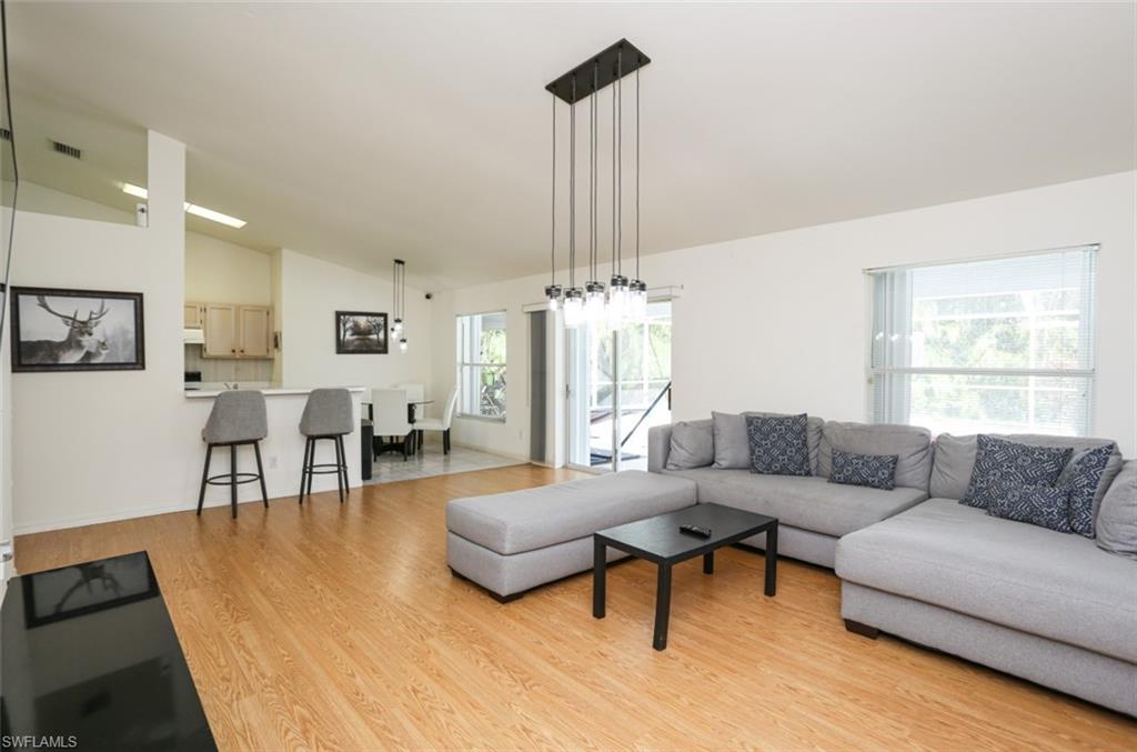 7775 Scarlet Court Naples, FL 34104 - Photo 13 of 30 Living room featuring lofted ceiling and light hardwood / wood-style flooring