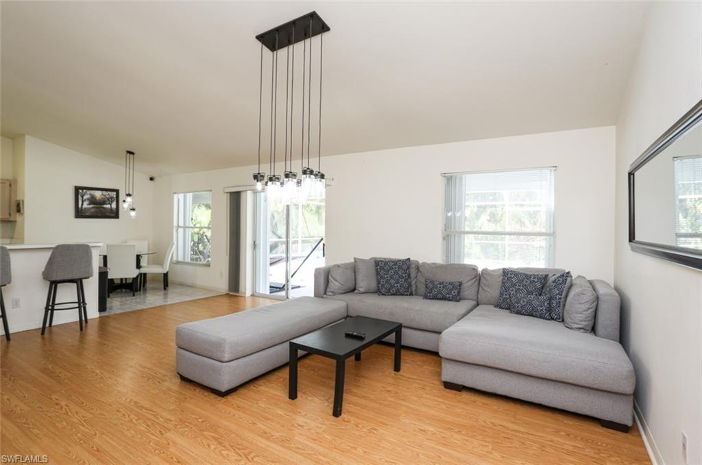 7775 Scarlet Court Naples, FL 34104 - Photo 15 of 30 Living room featuring lofted ceiling and light wood-type flooring