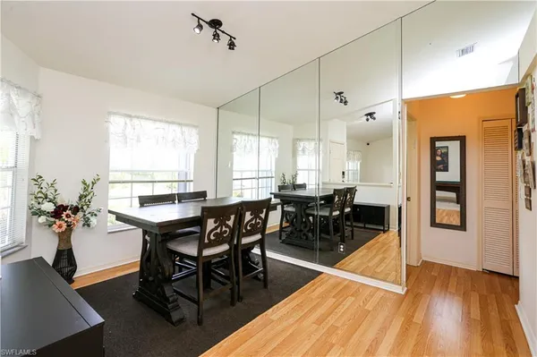 a view of a a dining room with furniture window and wooden floor