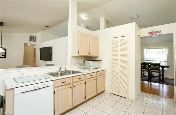 a kitchen with a sink window and cabinets