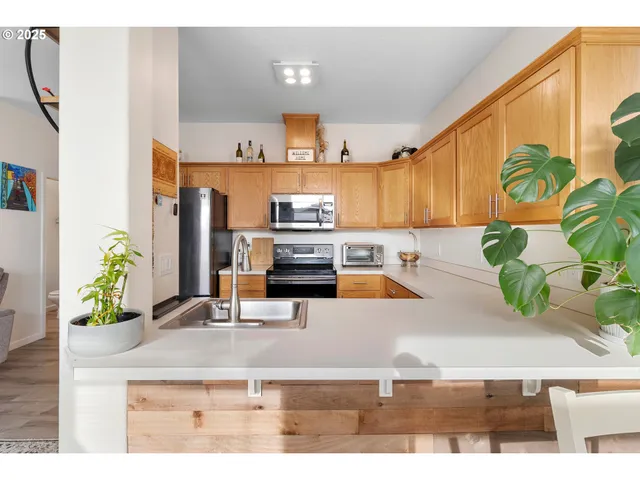 a kitchen with stainless steel appliances kitchen island granite countertop a refrigerator a stove and a sink