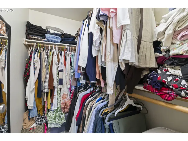a view of walk in closet with clothes