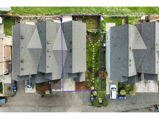 a aerial view of a house with large trees and outdoor seating