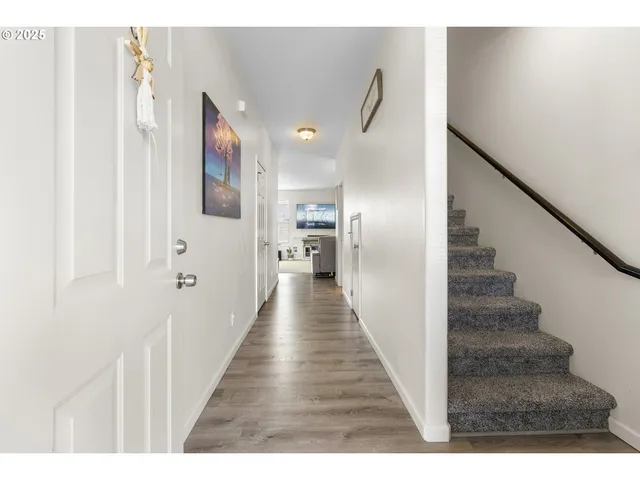 a view of a hallway with wooden floor and staircase