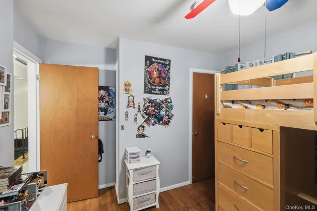 a view of a bedroom with wooden floor and cabinet