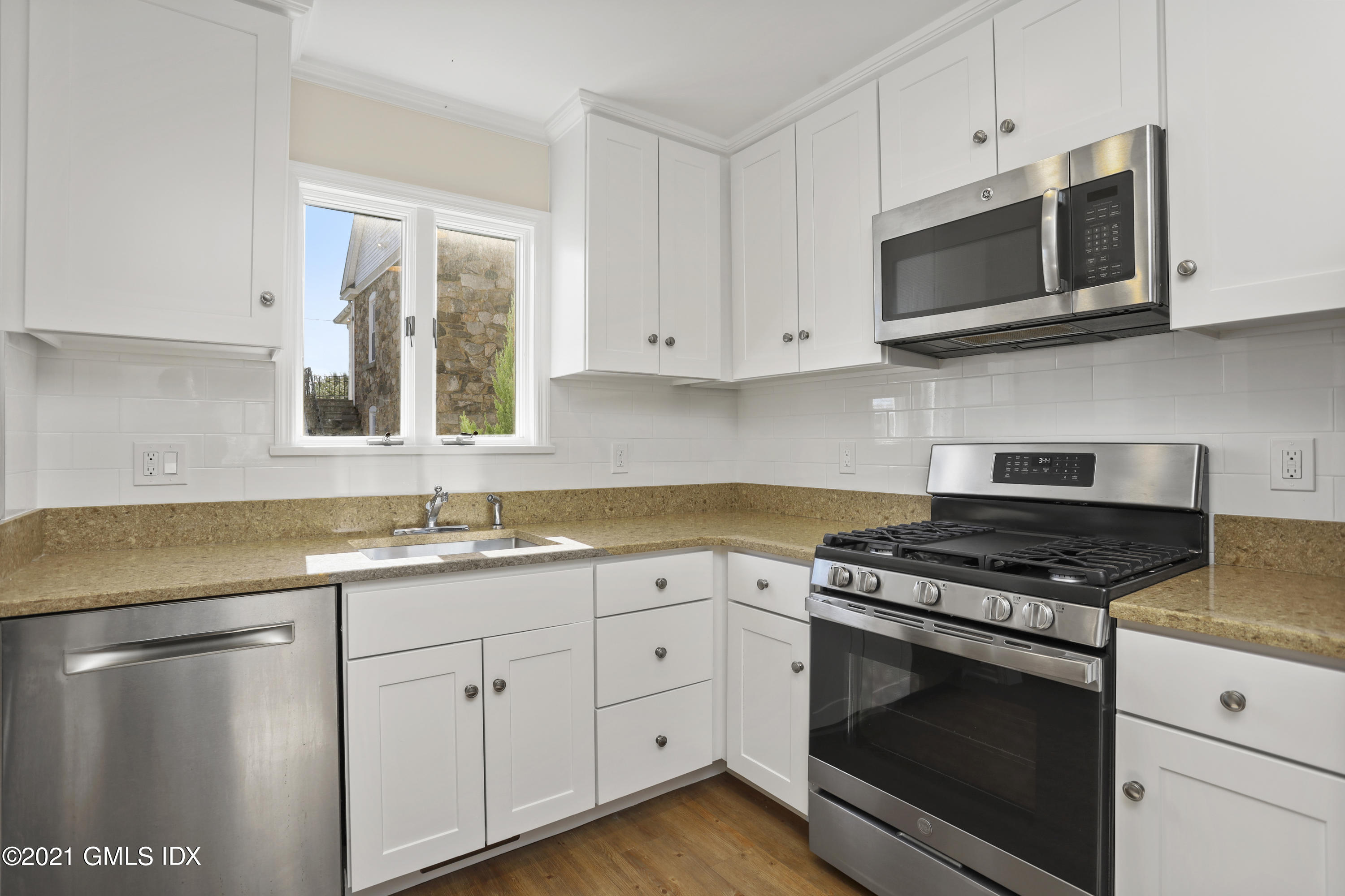 36 Decatur Street, Unit 2 Cos Cob, CT 06807 - Photo 6 of 30 a kitchen with stainless steel appliances granite countertop white cabinets a sink and dishwasher