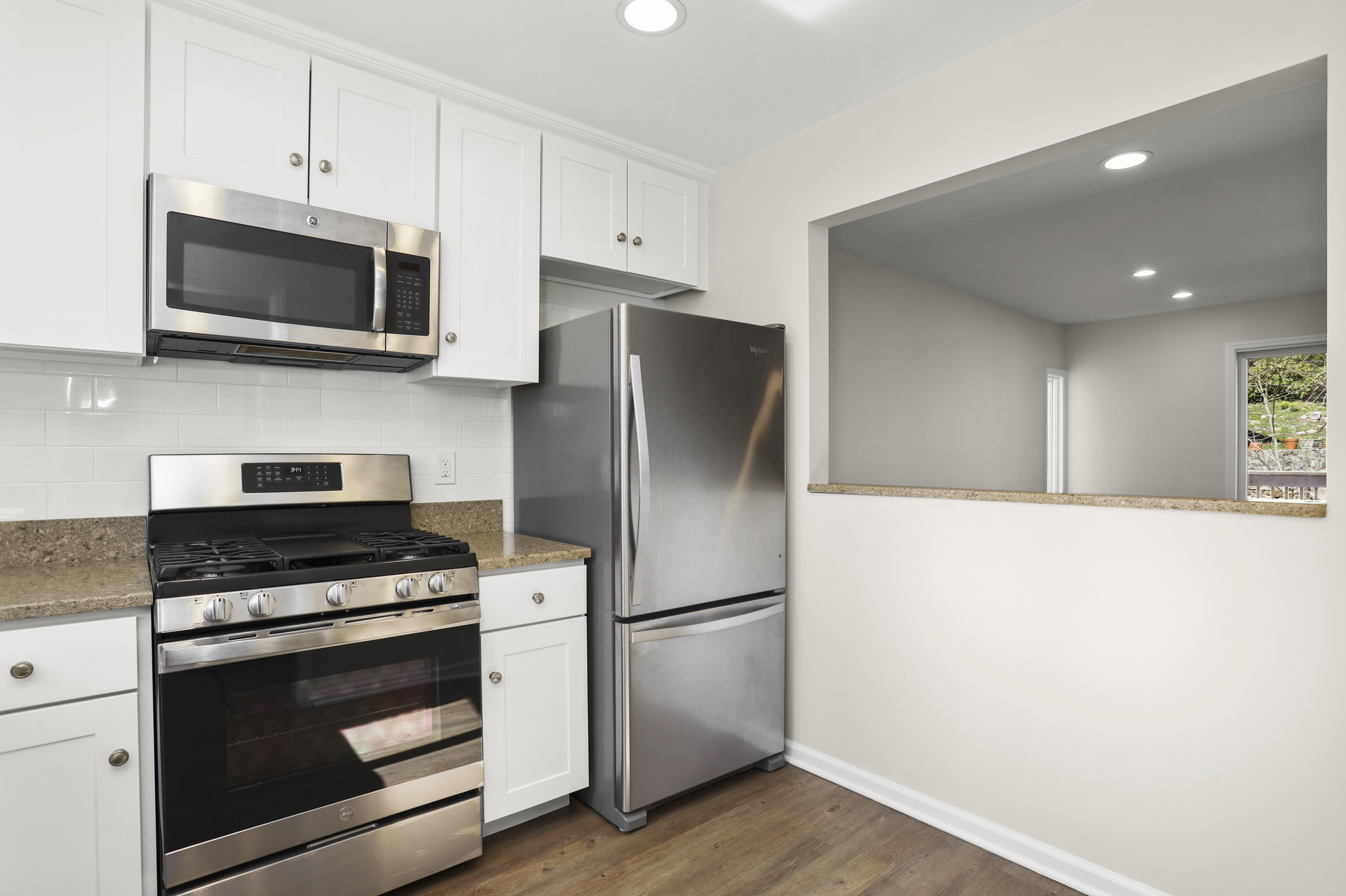 36 Decatur Street, Unit 2 Cos Cob, CT 06807 - Photo 7 of 30 a kitchen with stainless steel appliances white cabinets and a stove a refrigerator with wooden floor