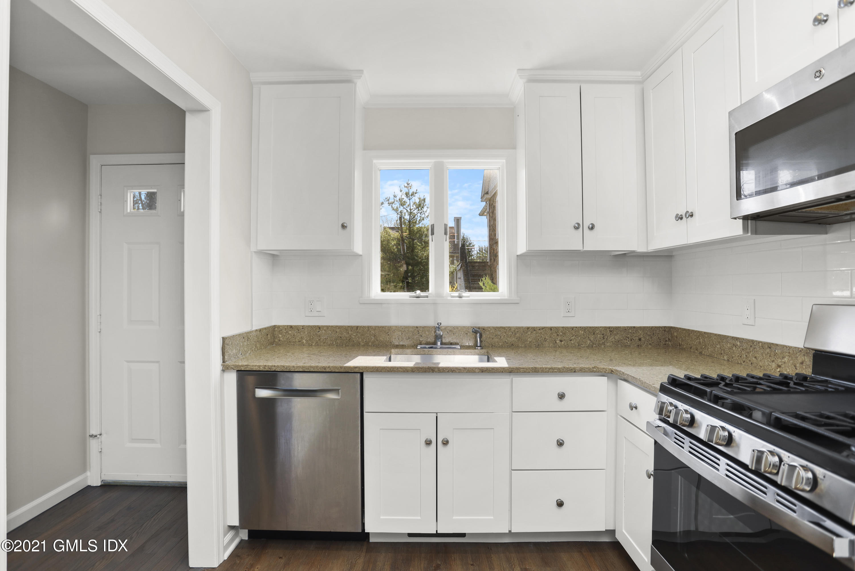 36 Decatur Street, Unit 2 Cos Cob, CT 06807 - Photo 8 of 30 a kitchen with white cabinets and a stove with wooden floor