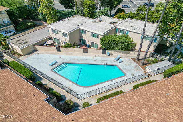 an aerial view of residential houses with outdoor space and trees
