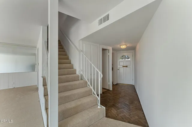 a view of a hallway with wooden floor and entryway