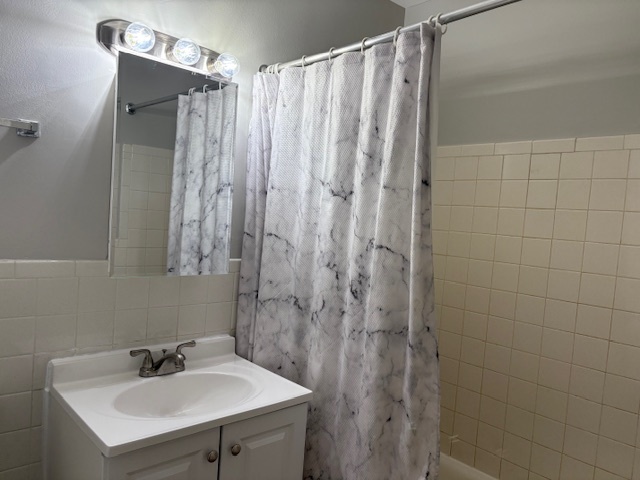 8923 Knight Avenue, Unit 201 Des Plaines, IL 60016 - Photo 12 of 13 a bathroom with a sink a mirror and shower curtain