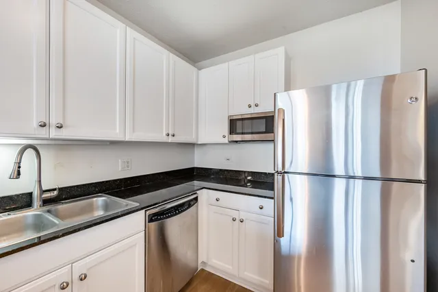 a kitchen with appliances a sink and cabinets
